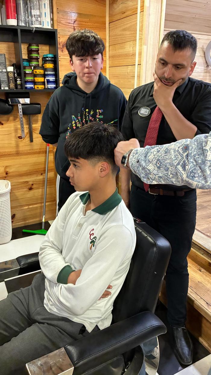 Alumnos del curso de barbería trabajando en el local